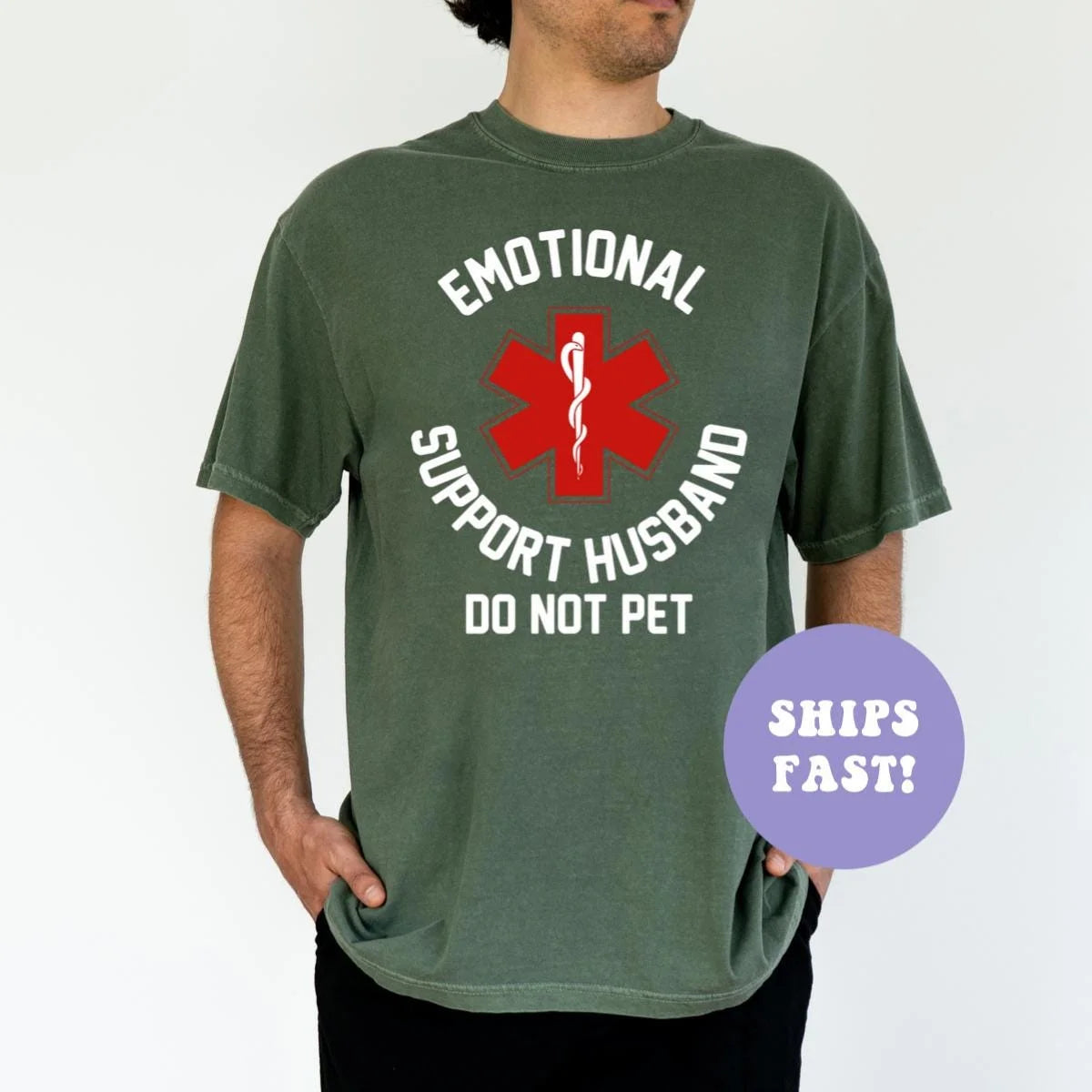 Man in a Moss green Comfort Colors tee, hands in pockets, with the red medical star and white do not pet text