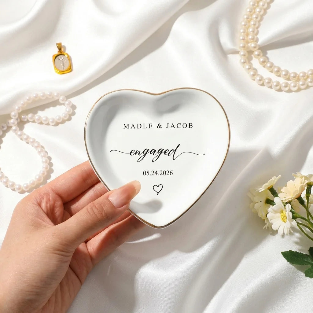 Engaged script ring dish styled with wedding rings and white flowers