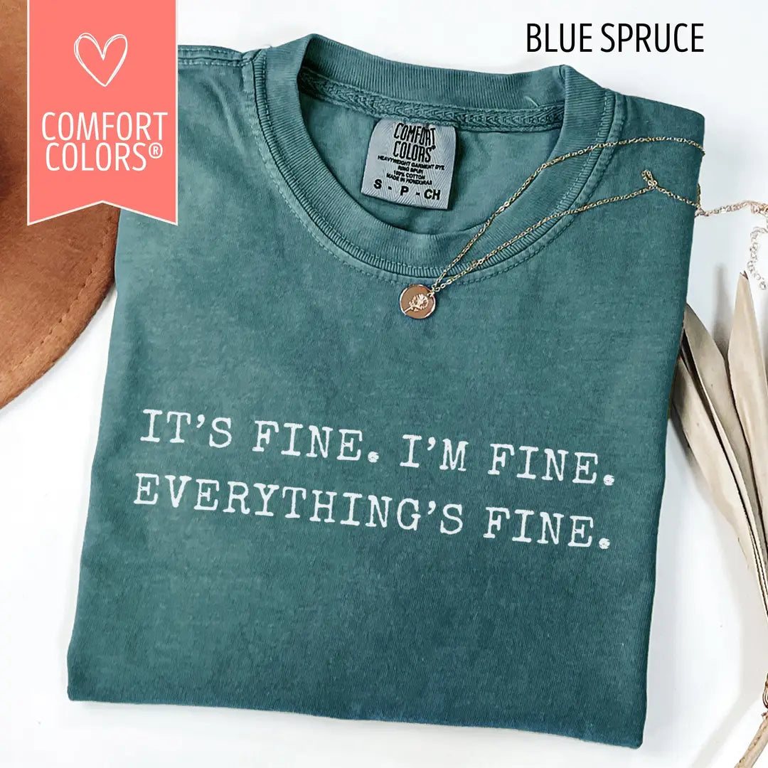 Blue Spruce Comfort Colors T-shirt with white 'It's Fine. I'm Fine. Everything's Fine.' typography, folded mockup.