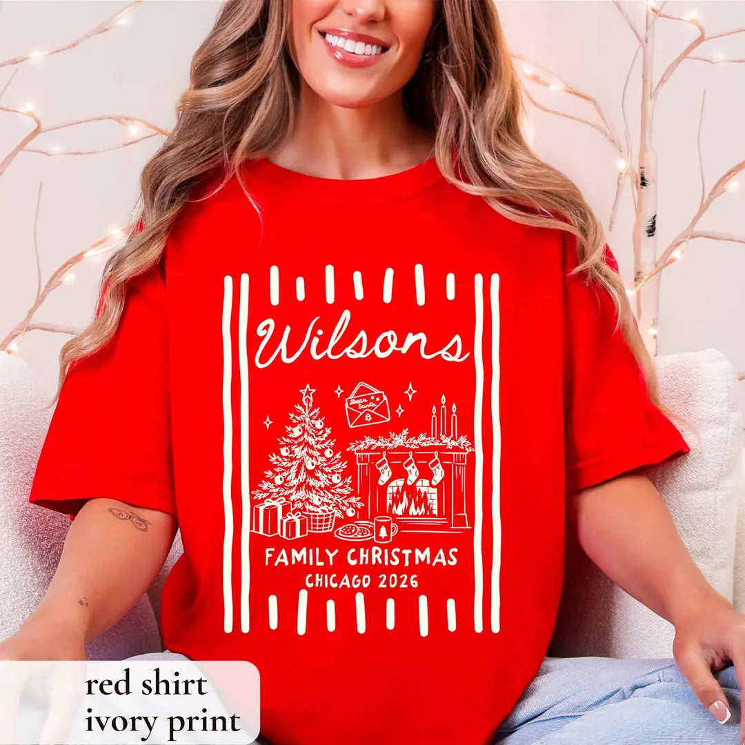 Smiling woman in a Red Comfort Colors tee on a white couch, ivory Wilsons script, tree and fireplace between stripes