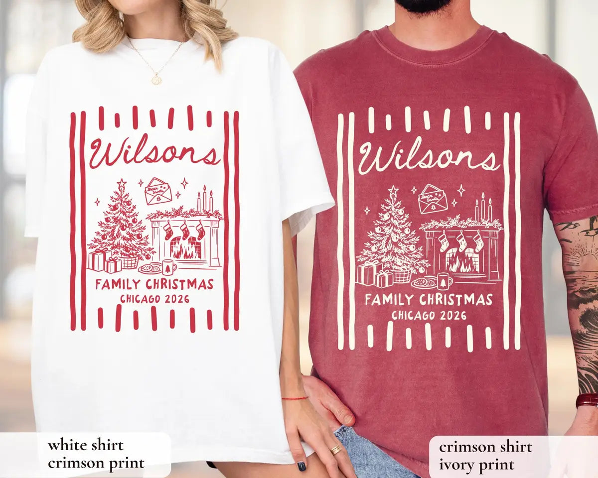 Woman and man in White and Crimson Comfort Colors tees, Wilsons script with a tree, fireplace, stockings and stripes