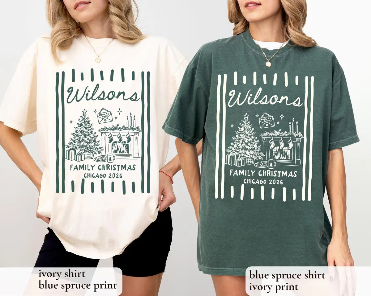 Woman and man in Ivory and Blue Spruce Comfort Colors tees, Wilsons Family Christmas, Chicago 2026 tree and fireplace