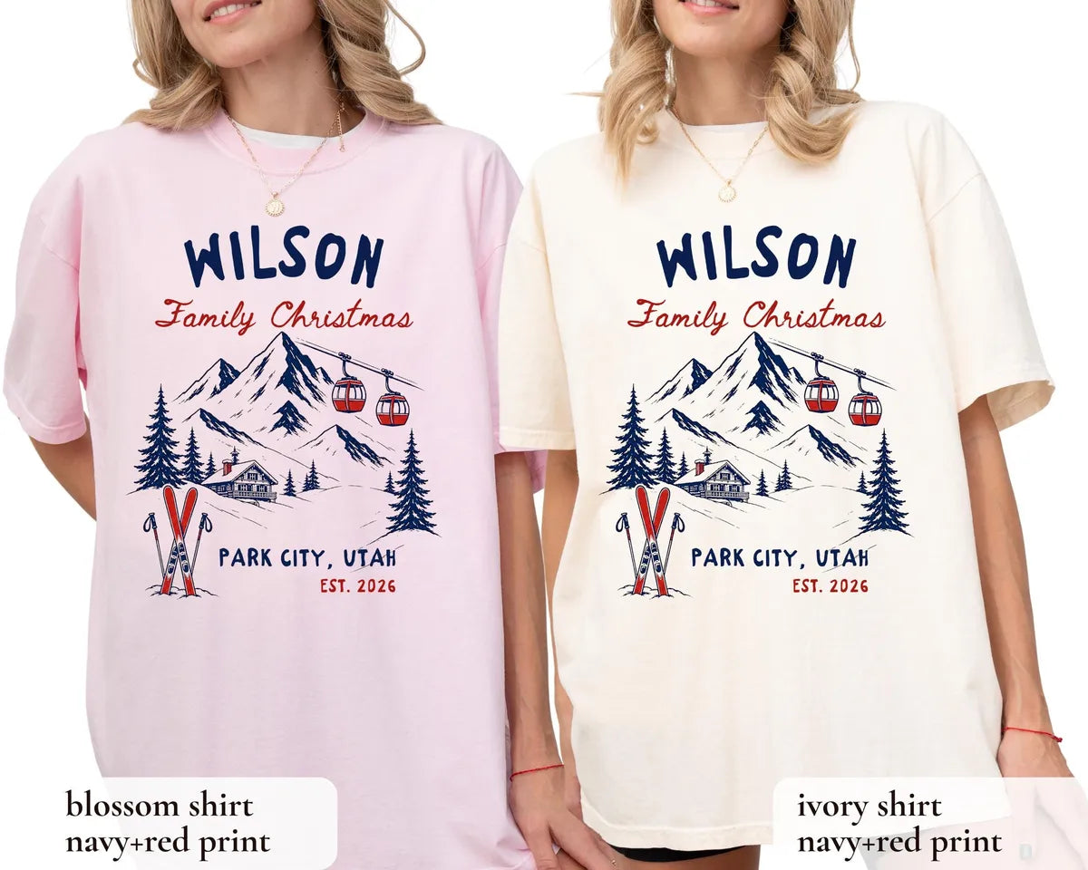 Two women in Blossom pink and Ivory Comfort Colors tees, each with a navy and red ski mountain, gondolas and Est. 2026