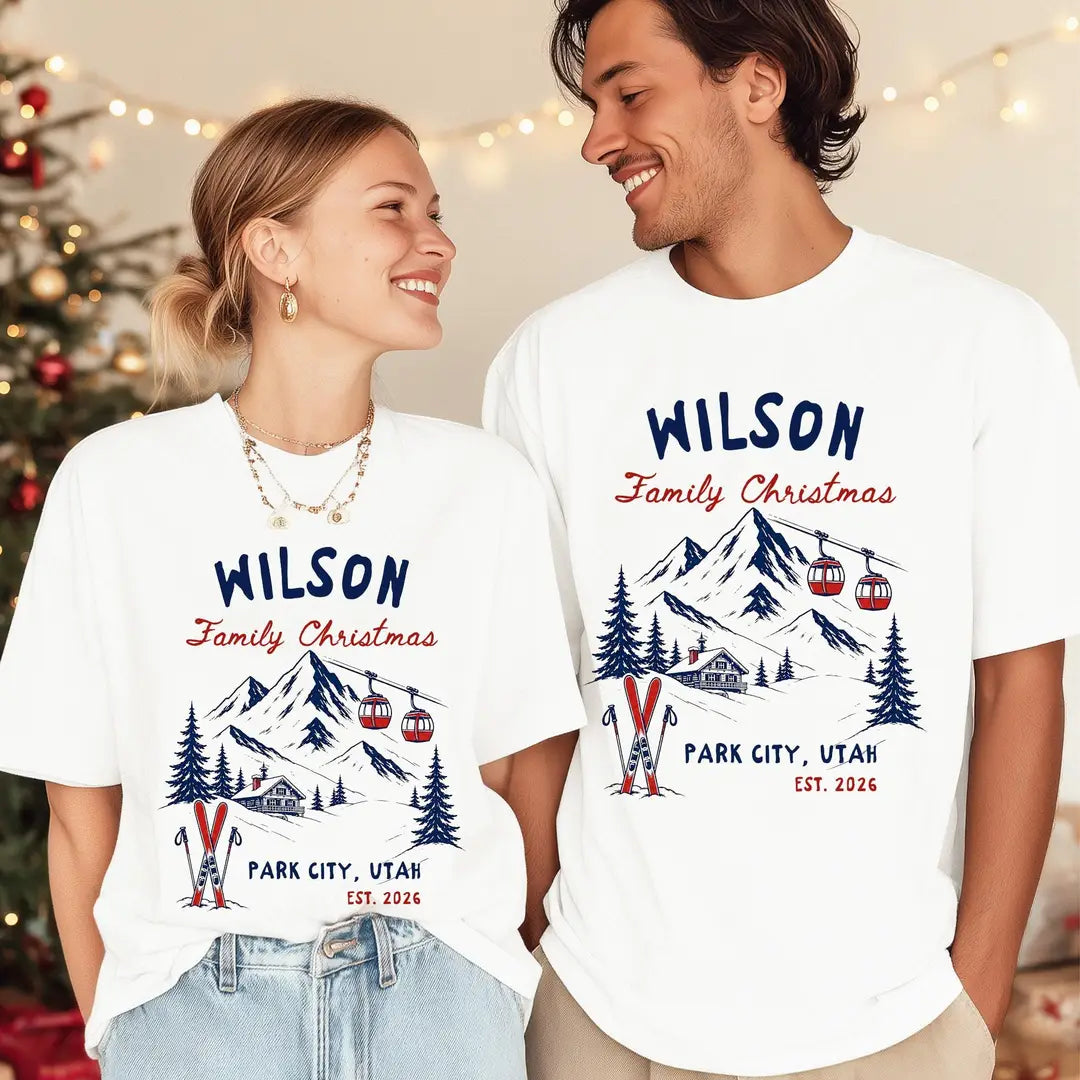 Woman and man by a christmas tree in White Comfort Colors tees, navy and red Wilson Family Christmas ski mountain, Park City