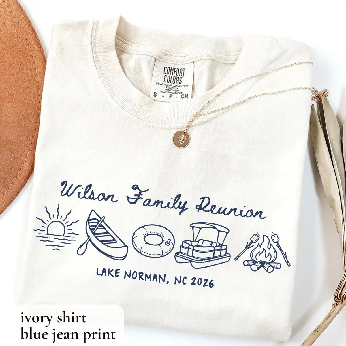 Folded Ivory Comfort Colors tee beside a tan hat with blue jean Wilson Family Reunion, canoe, tube and Lake Norman, NC
