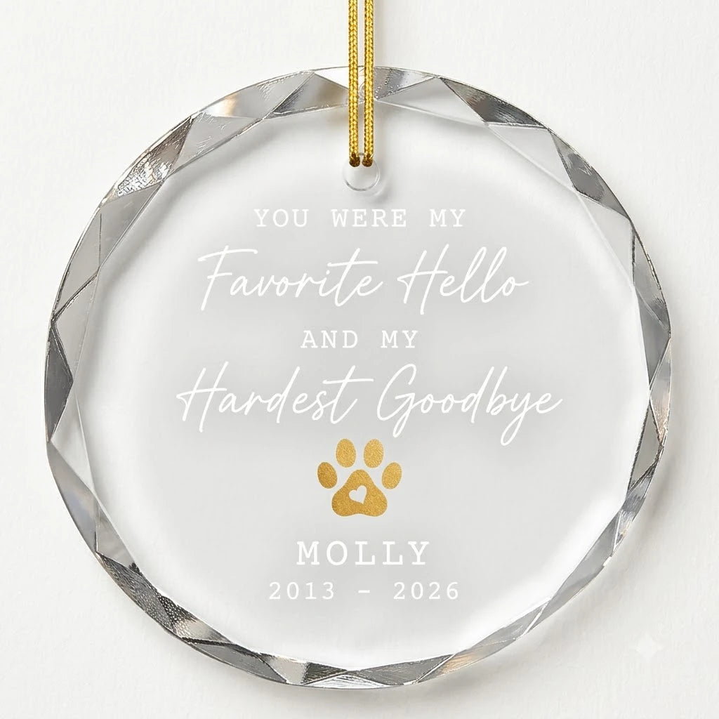Beveled edge clear glass round ornament featuring printed gold dog cat paw print with heart graphics, custom text Favorite Hello Hardest Goodbye and personalized details hanging on gold ribbon