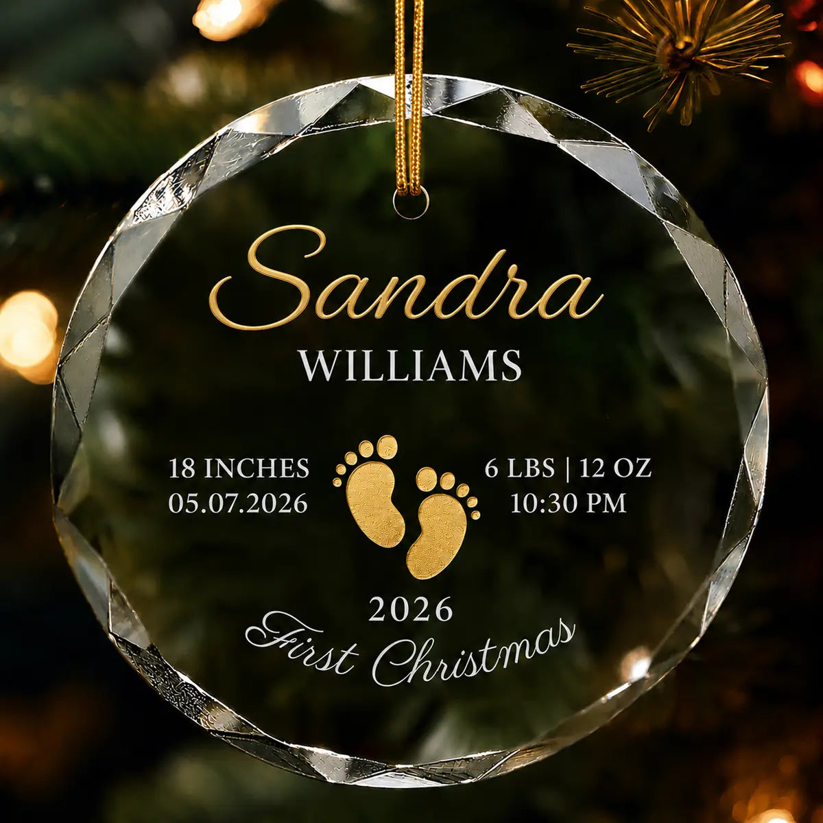 Clear glass round ornament featuring gold baby footprints and custom birth statistics details with detail view
