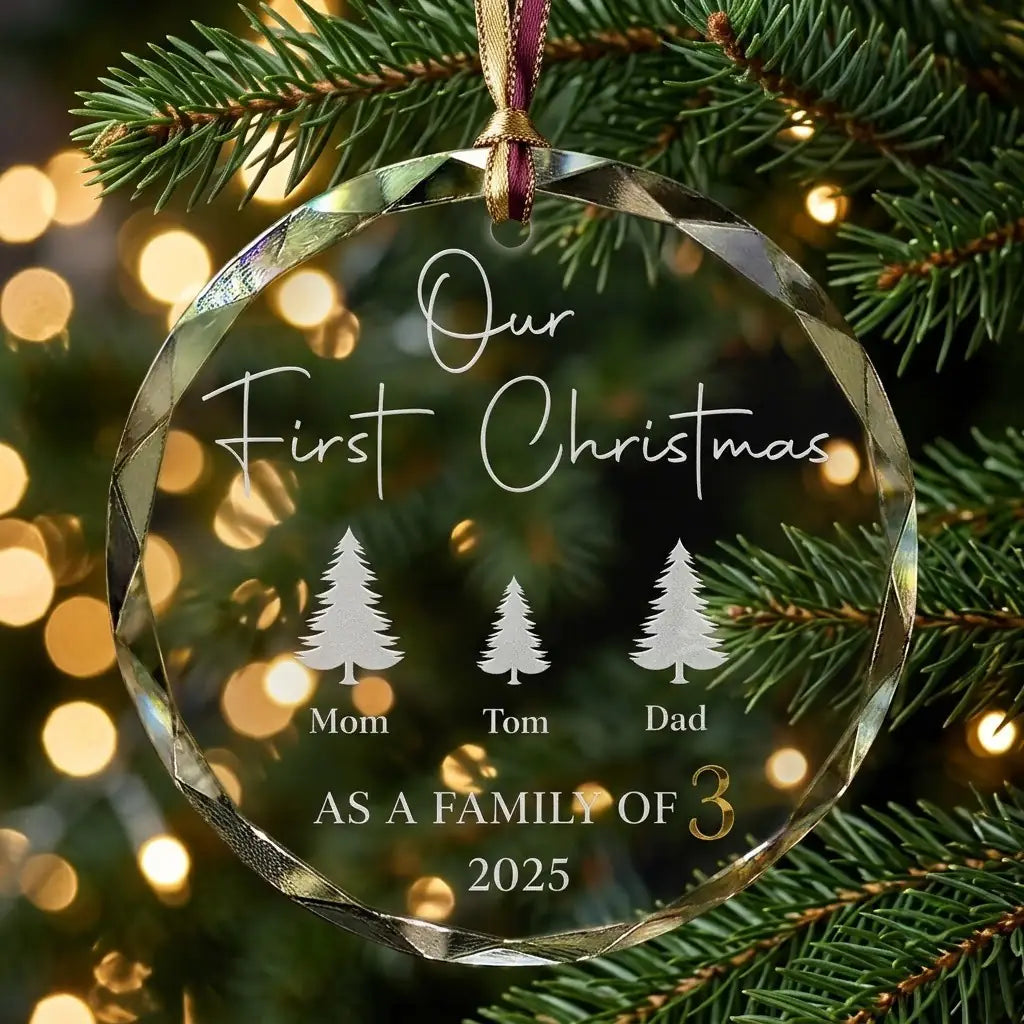 Personalized clear glass family of 3 ornament displayed hanging on Christmas tree branch with warm sparkling holiday lights background