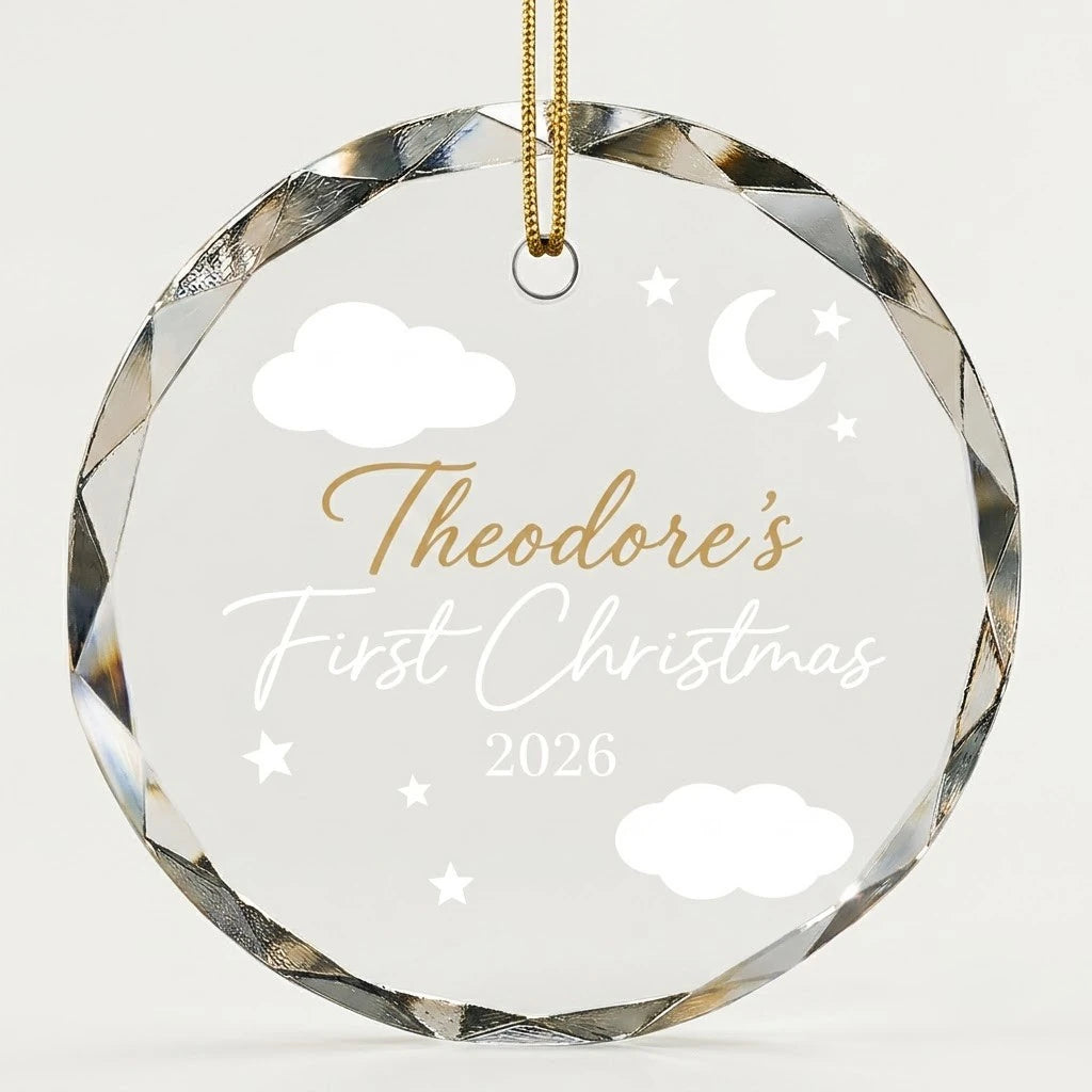 Beveled edge clear glass round ornament featuring printed crescent moon clouds and stars graphics, custom text First Christmas and personalized details hanging on gold ribbon