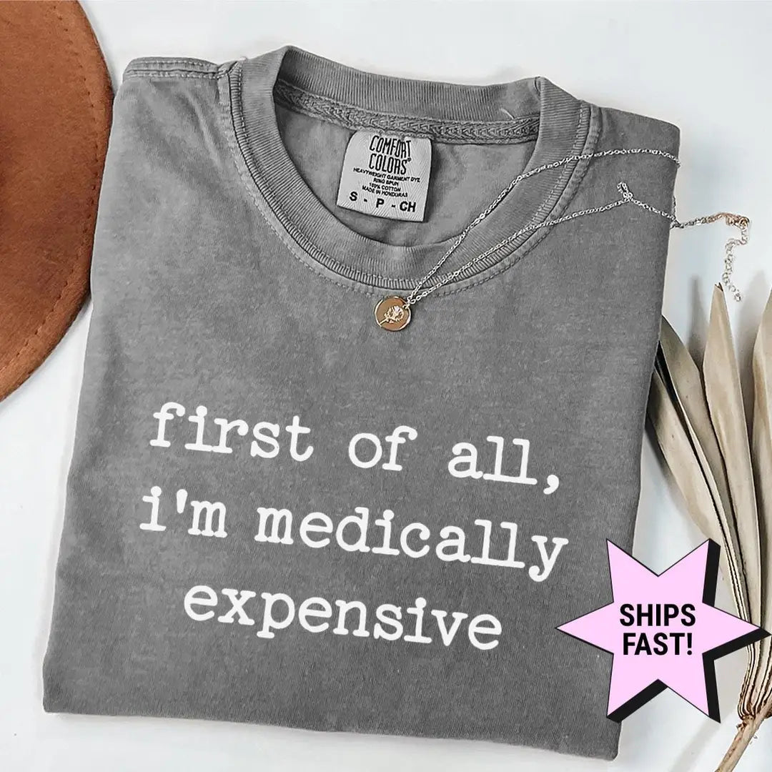 Folded Pepper Comfort Colors tee with first of all, i'm medically expensive in white typewriter type, necklace at the collar