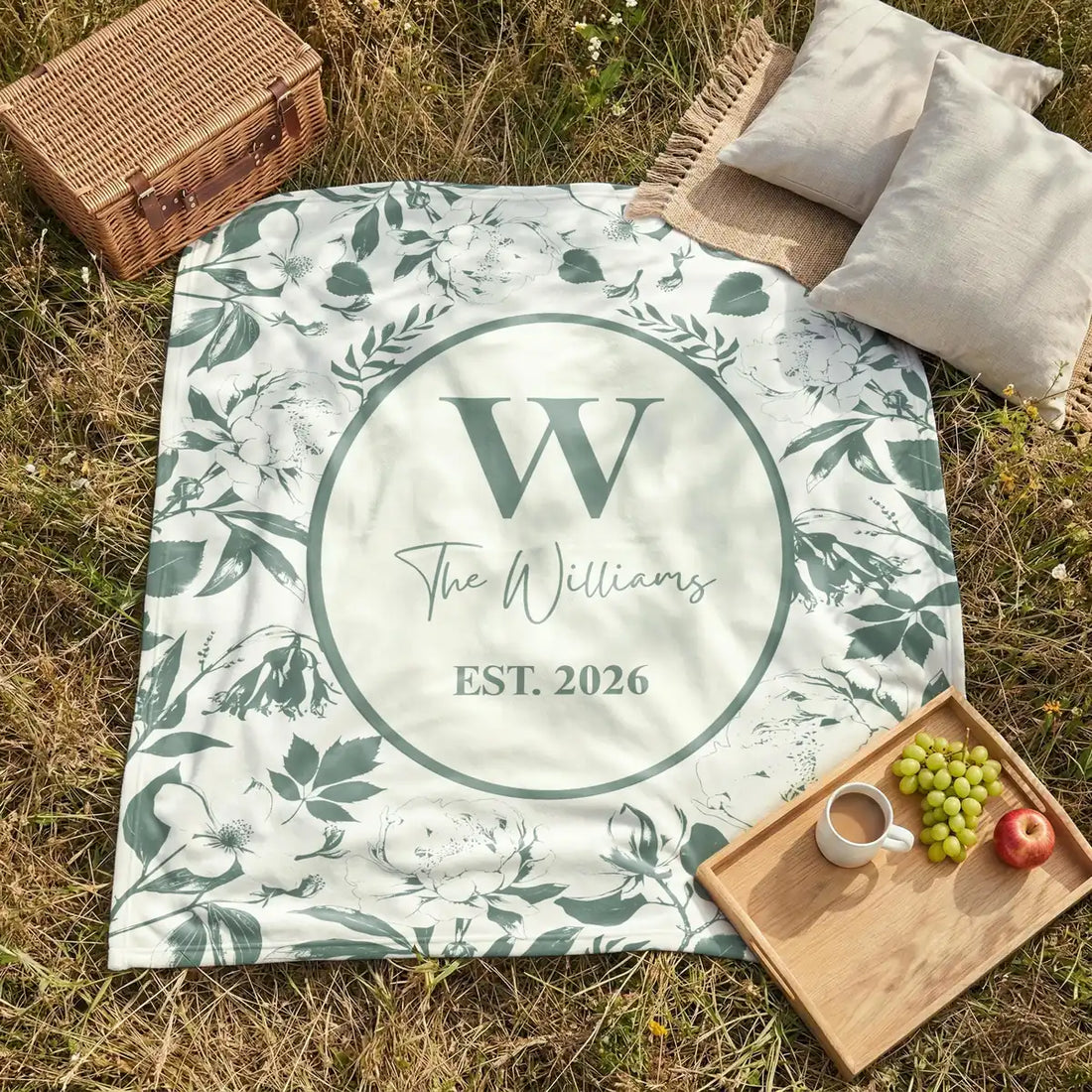 Close-up of the personalized floral toile woven blanket with monogram and fringe detail