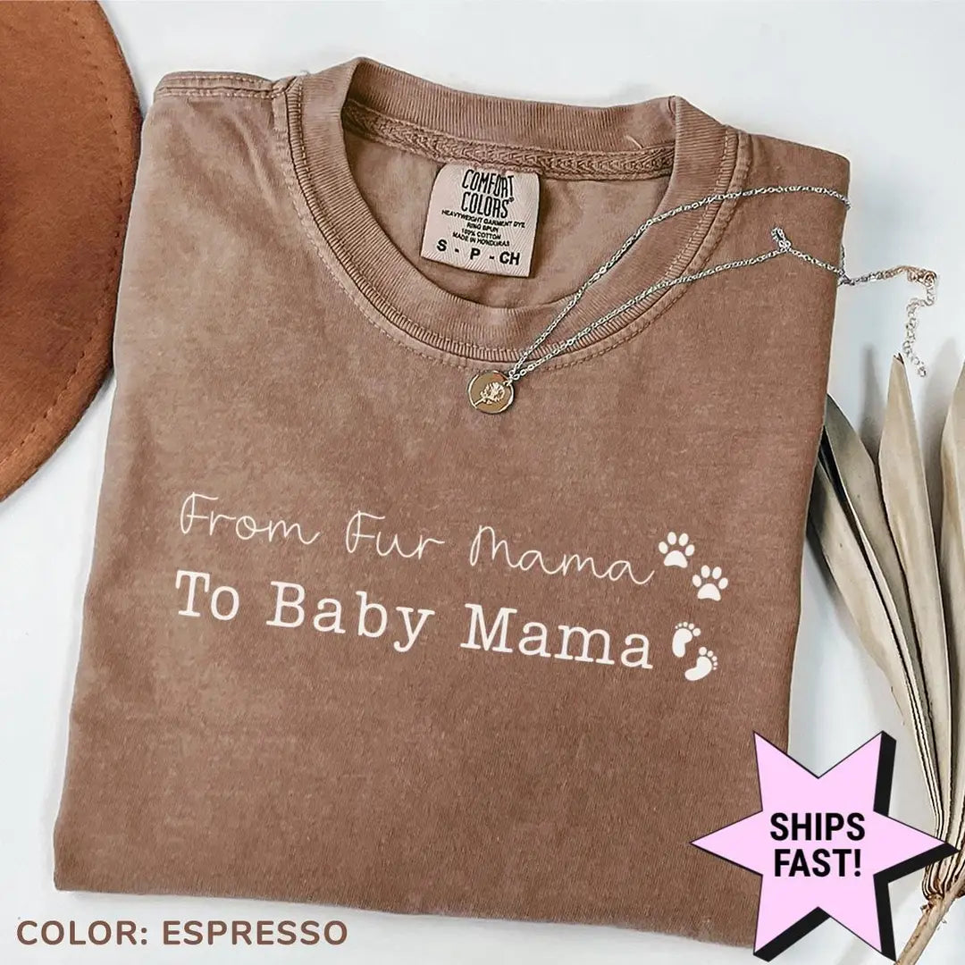 Folded Espresso brown Comfort Colors tee with white from fur mama to baby mama text, paw print, baby feet and a brown hat
