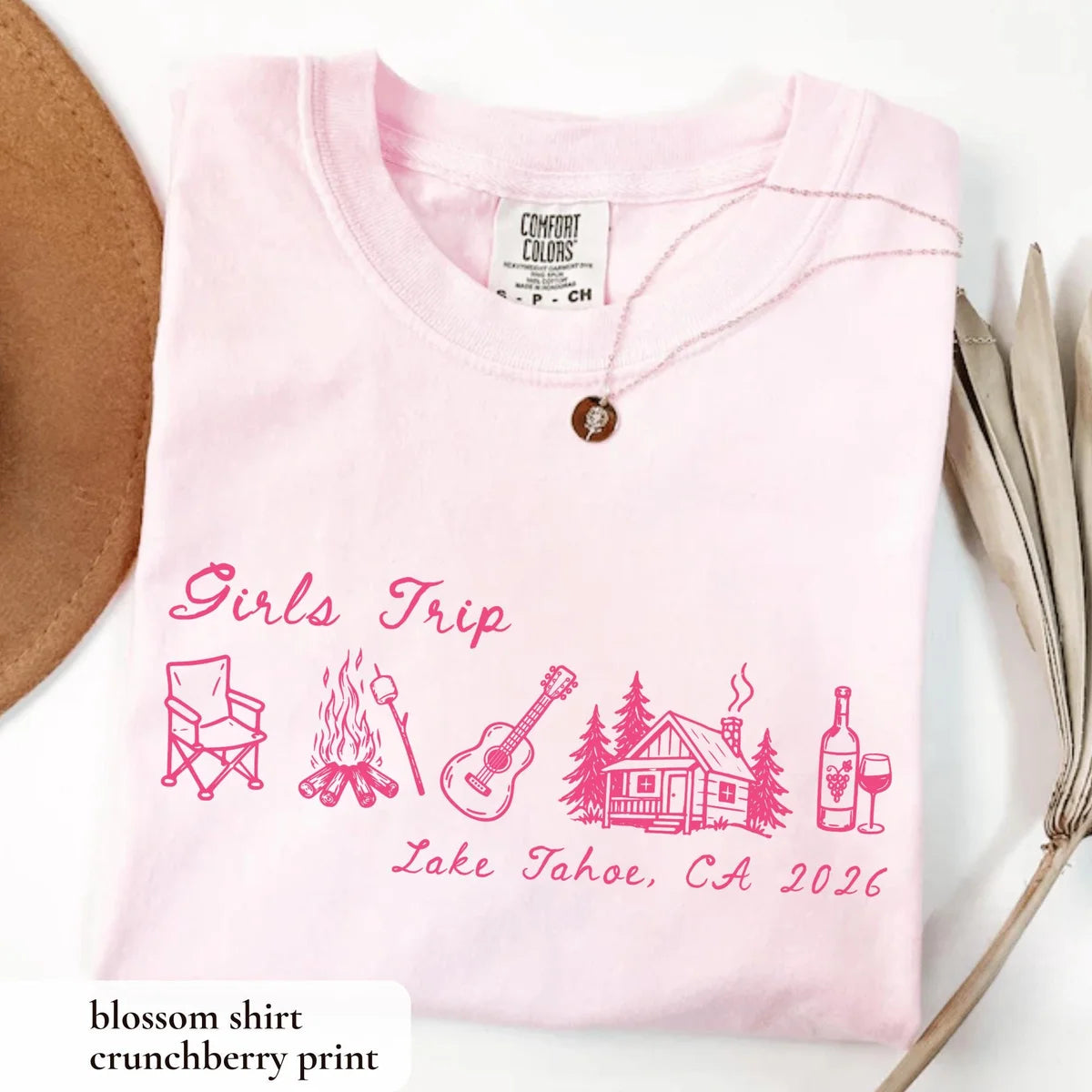 Folded Blossom pink Comfort Colors tee with hot pink girls trip script, camp chair, guitar, cabin and wine glass