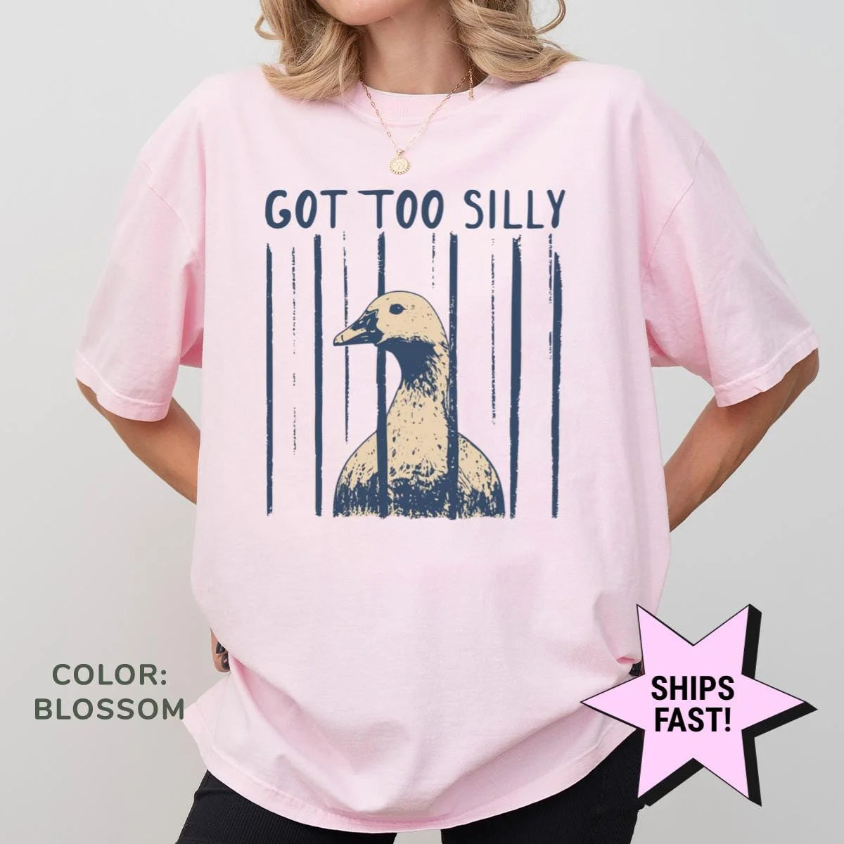 Woman in a Blossom pink Comfort Colors tee, hands on hips, with navy got too silly text and a tan and navy goose head