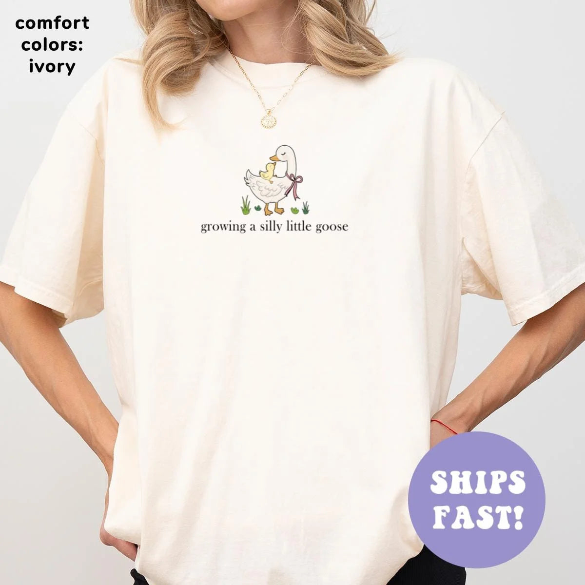 Woman in an Ivory Comfort Colors tee, hands on hips, with a bowed goose and ducklings above the small goose caption