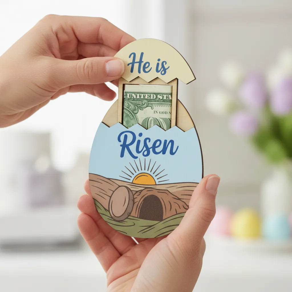 Easter egg-shaped card with 'He is Risen' text and a dollar bill, held by a hand.