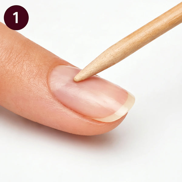 Close-up of a wooden tool being used on a person's nail