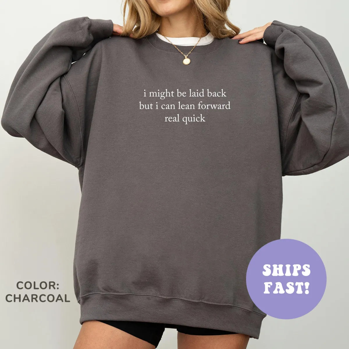 Woman in a Charcoal sweatshirt, hands raised to her shoulders, cream quote, I might be laid back but I can lean forward