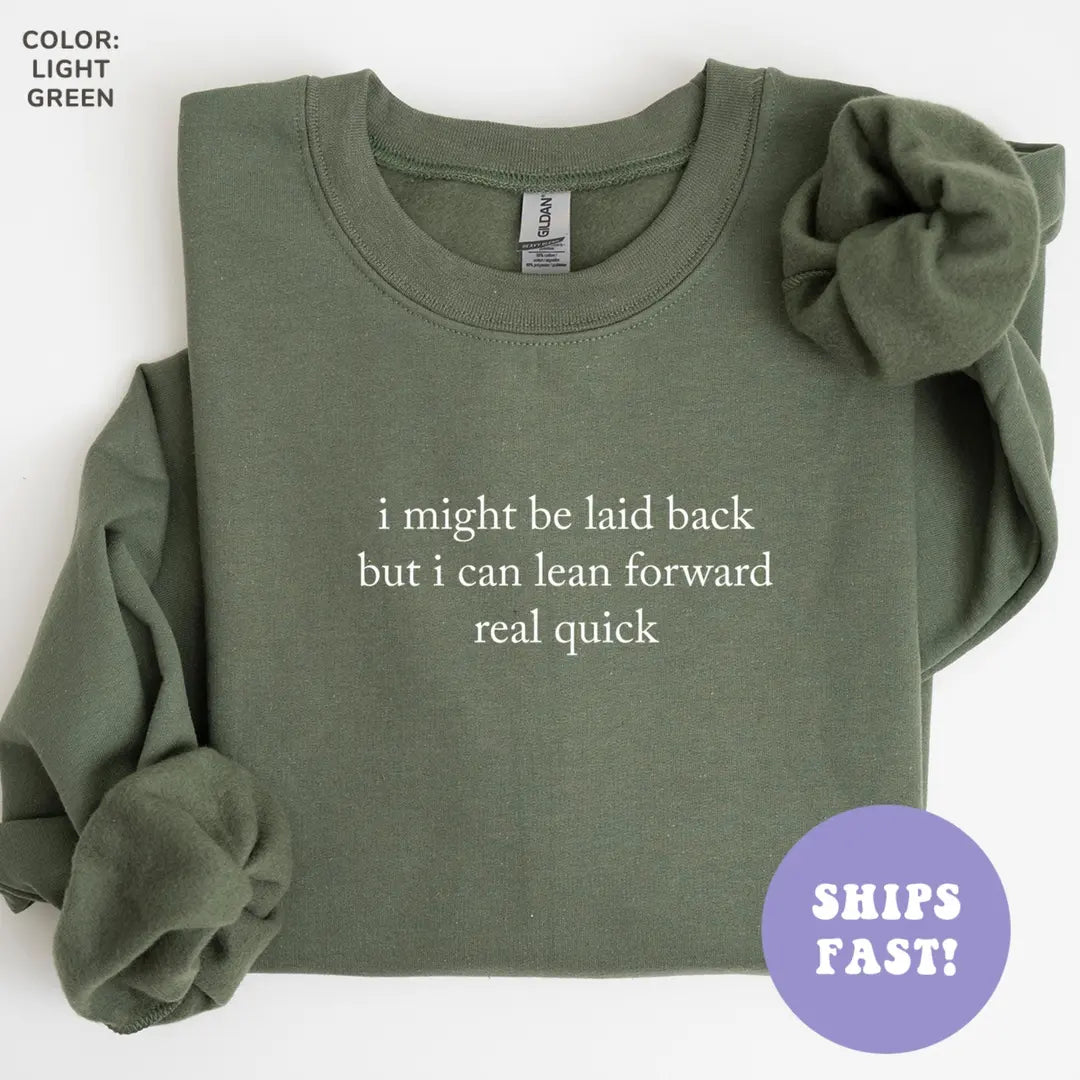 Flat lay Military Green sweatshirt with a cream serif quote, I might be laid back but I can lean forward real quick