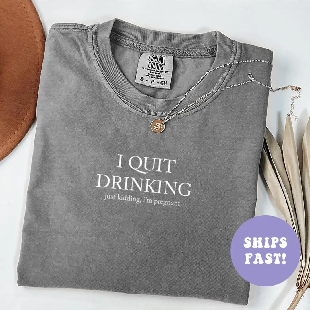 Folded Pepper Comfort Colors tee with I QUIT DRINKING in white serif capitals over a tiny just kidding, i'm pregnant line