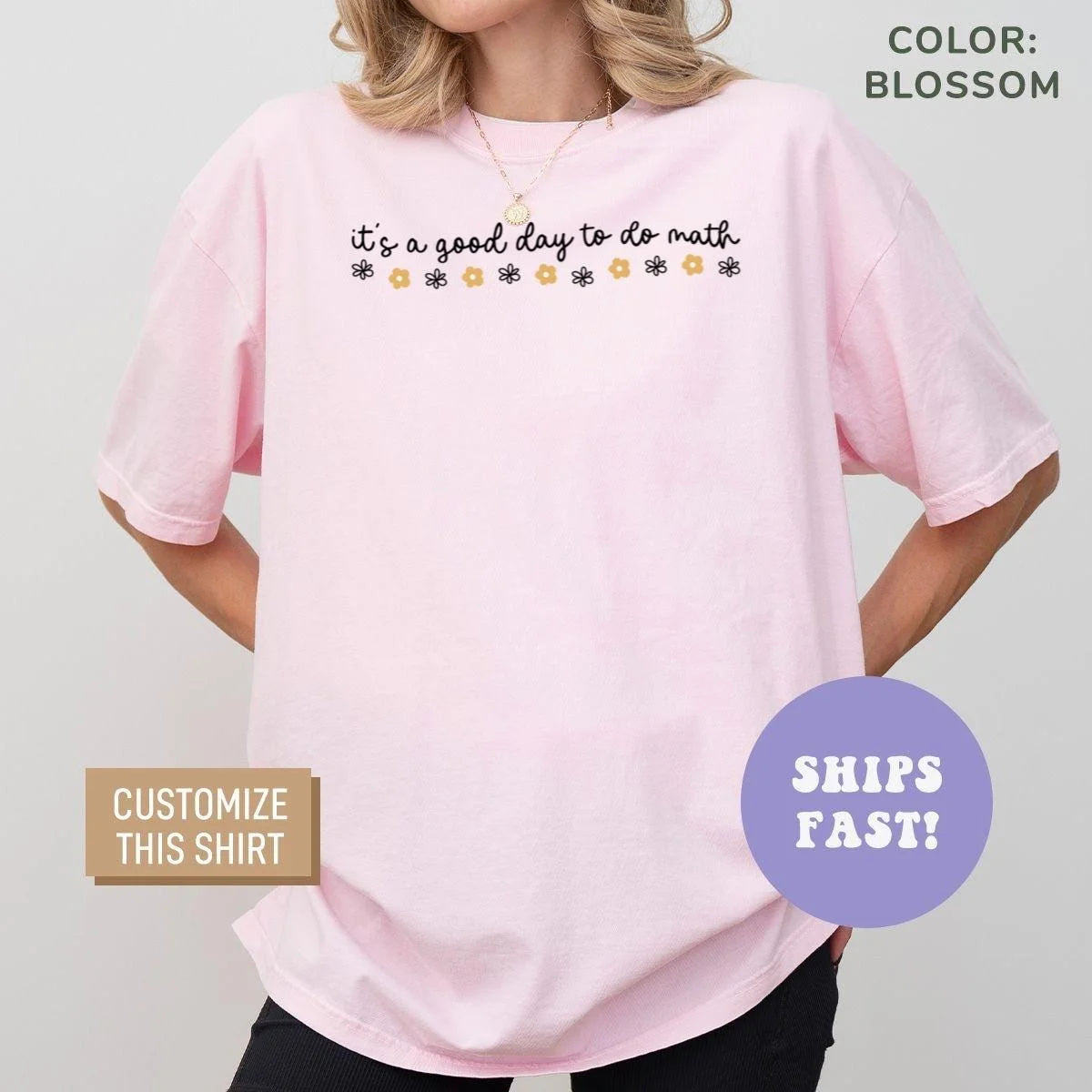 Woman in a Blossom pink Comfort Colors tee with black cursive do math text over a row of yellow and purple daisies