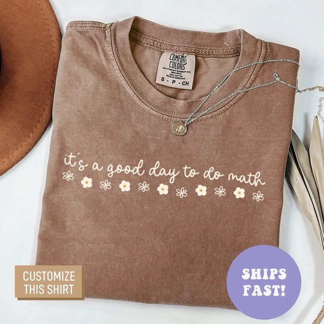 Folded Espresso brown Comfort Colors tee with the do math cursive quote and cream daisies, brown hat at the corner