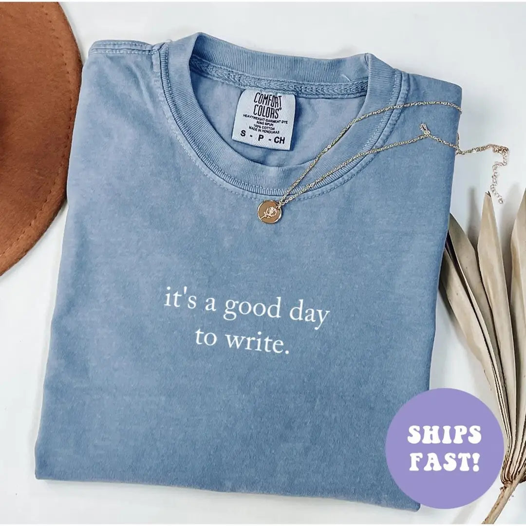 Folded Blue Jean Comfort Colors tee with the two-line good day to write quote in white serif type