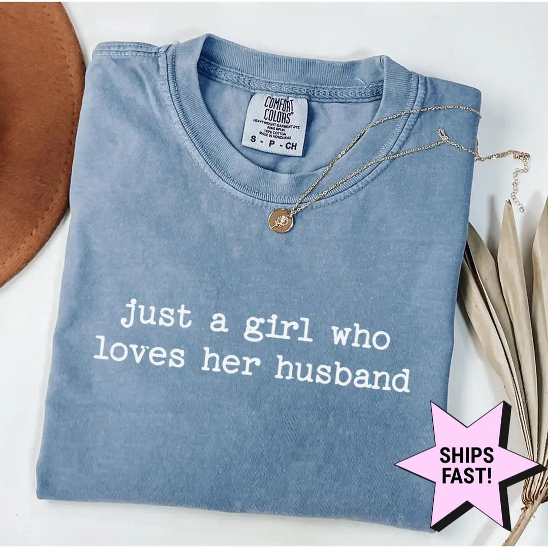 Folded Blue Jean Comfort Colors tee with the quote just a girl who loves her husband in white lowercase letters