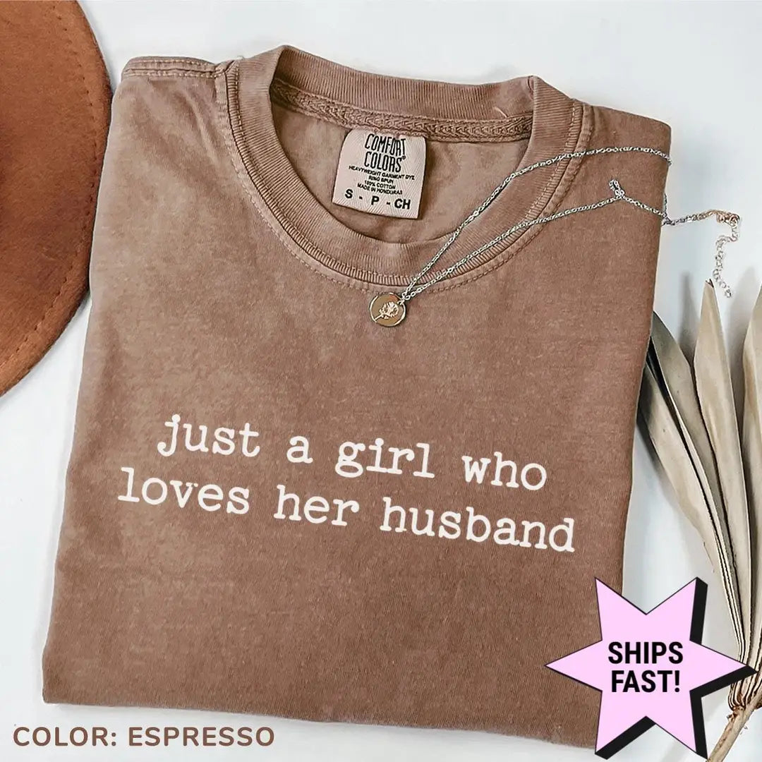 Folded Espresso brown Comfort Colors tee with just a girl who loves her husband in light typewriter lettering