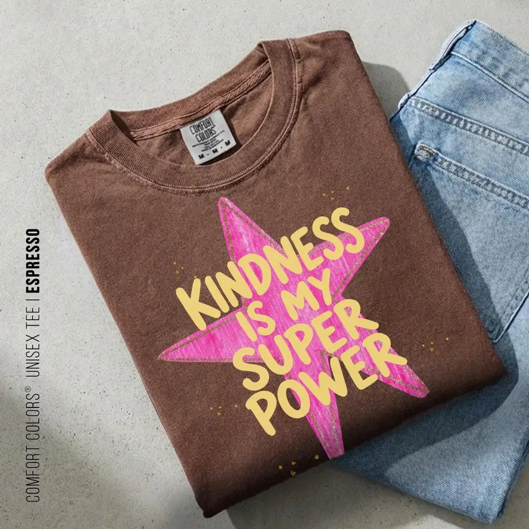 Folded Espresso brown Comfort Colors tee on blue jeans with yellow kindness is my super power over a pink star