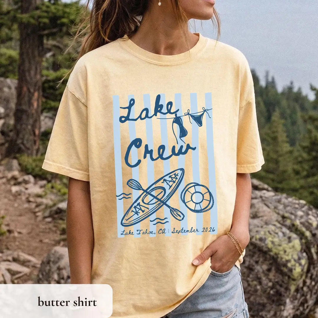 Woman in a Butter yellow Comfort Colors tee on a rocky ledge, navy lake crew over blue stripes with a kayak