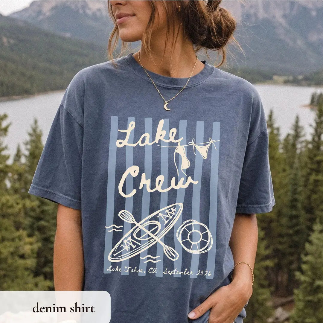 Woman in a Denim Comfort Colors tee wearing a crescent moon necklace, lake crew lettering above a kayak and Lake Tahoe line