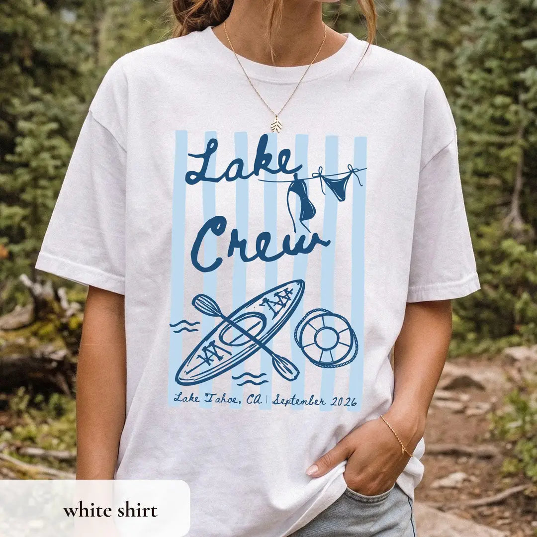 Woman in a White Comfort Colors tee on a mountain path, navy lake crew over light blue stripes with a kayak and ring