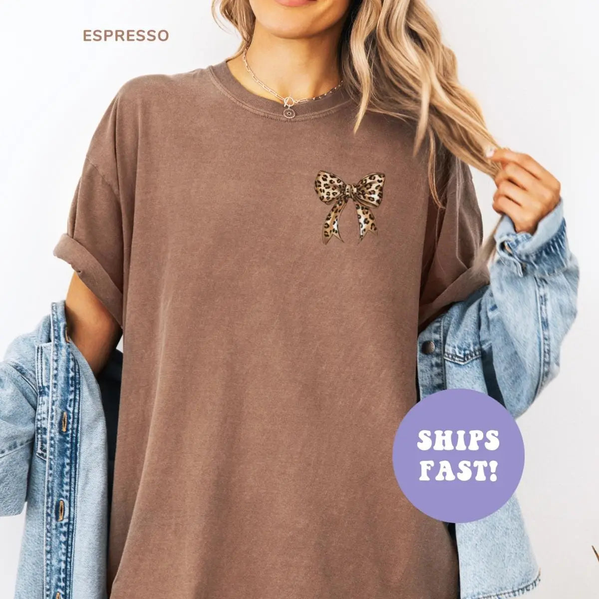 Espresso brown Comfort Colors tee worn loose, the leopard bow with spotted ribbon tails beside a lifted lock of hair