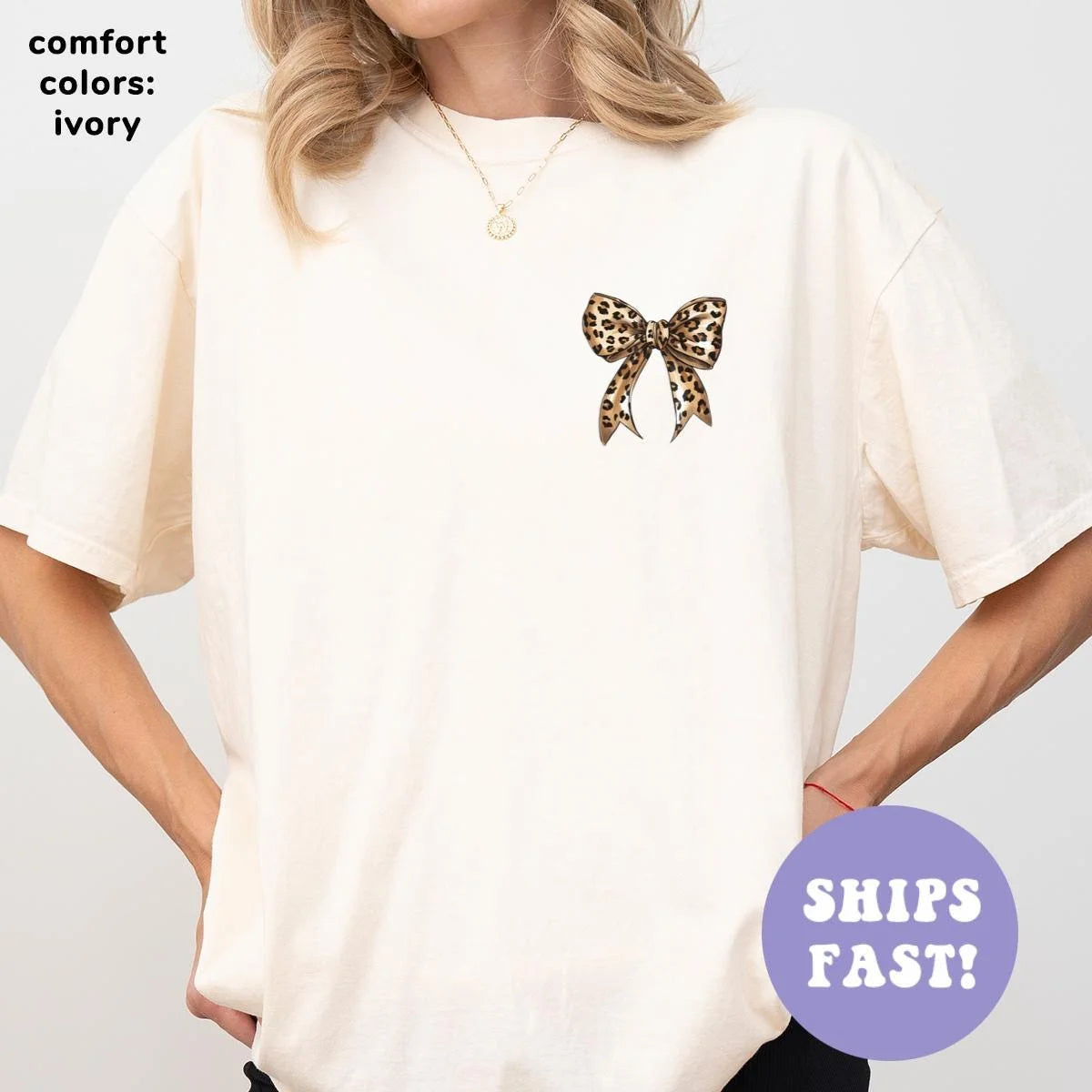Woman in an Ivory Comfort Colors tee, hands on hips, with a leopard print bow on the left chest