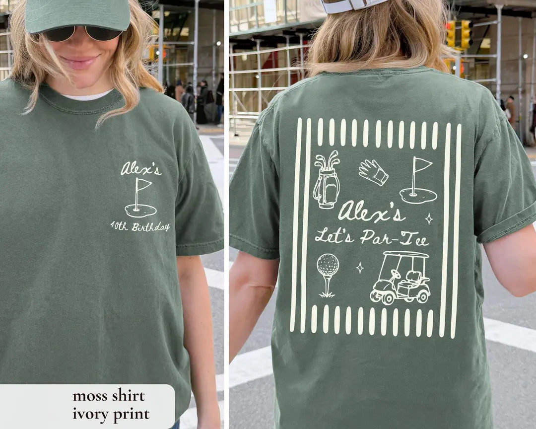Moss tee with an ivory print labeled in the corner, golf flag on the chest and a golf bag, glove and cart on the back