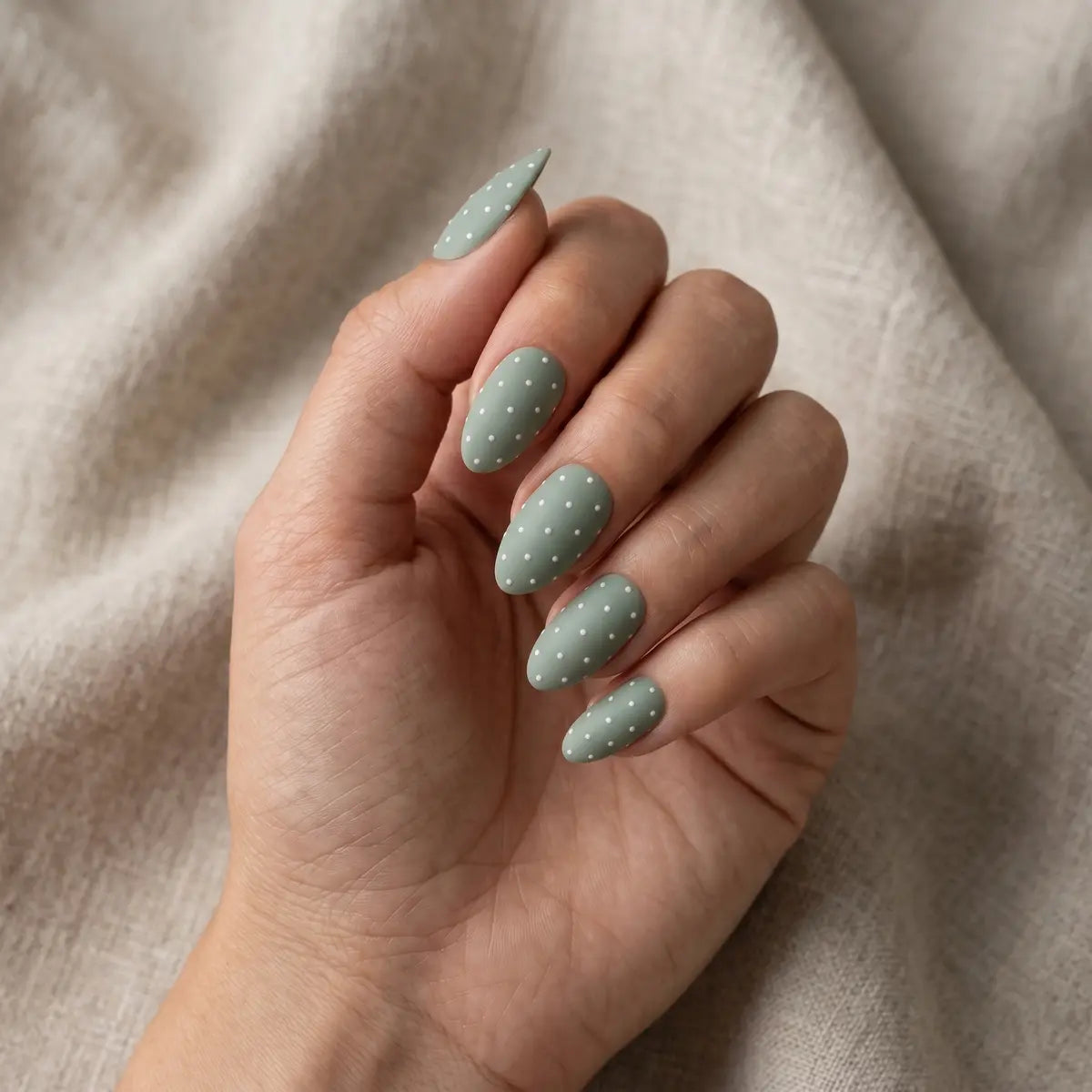 matte sage green hand painted almond press on nails white dot cross flat lay 04