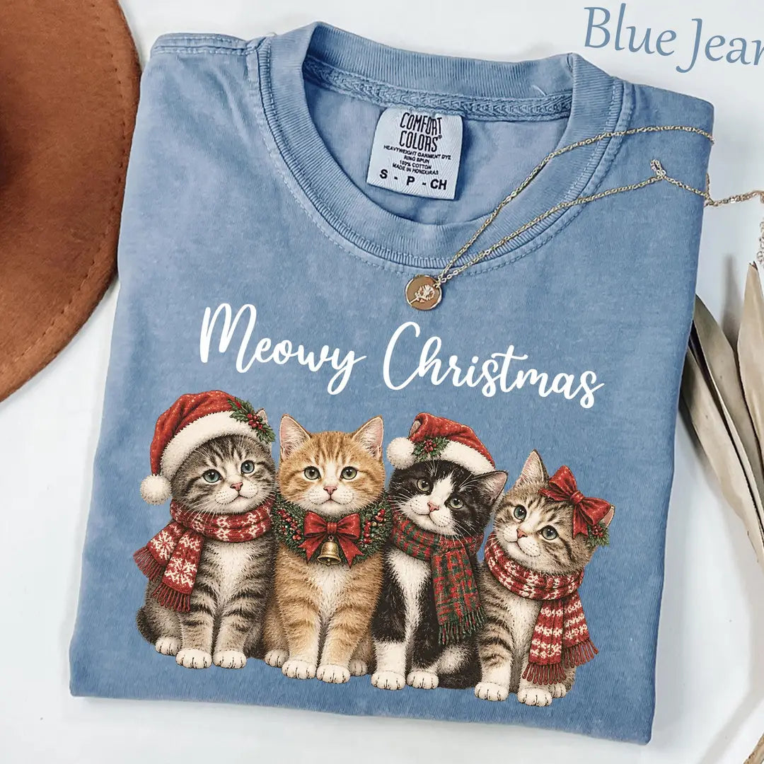 Folded Blue Jean Comfort Colors tee with white meowy christmas script above four scarf-wearing kittens in santa hats