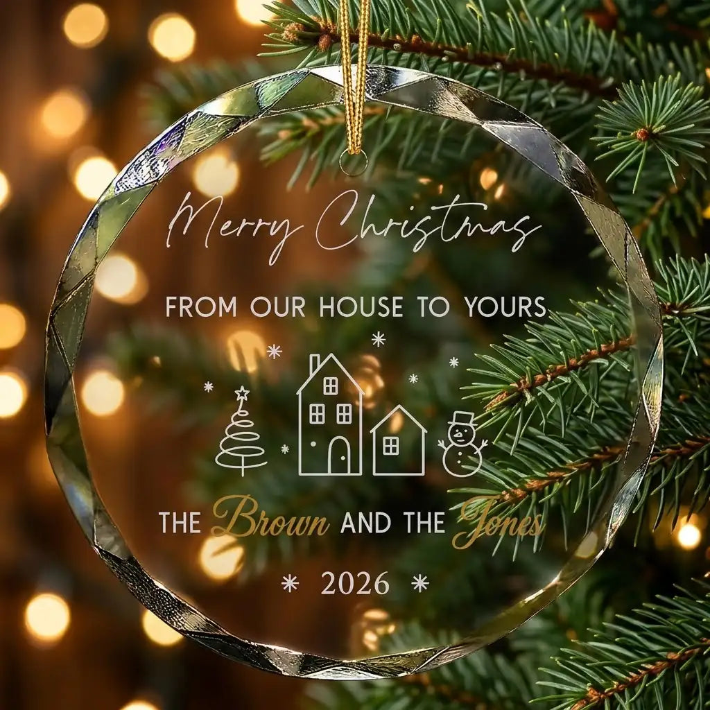 Personalized clear glass neighbor holiday ornament displayed hanging on Christmas tree branch with warm sparkling holiday lights background
