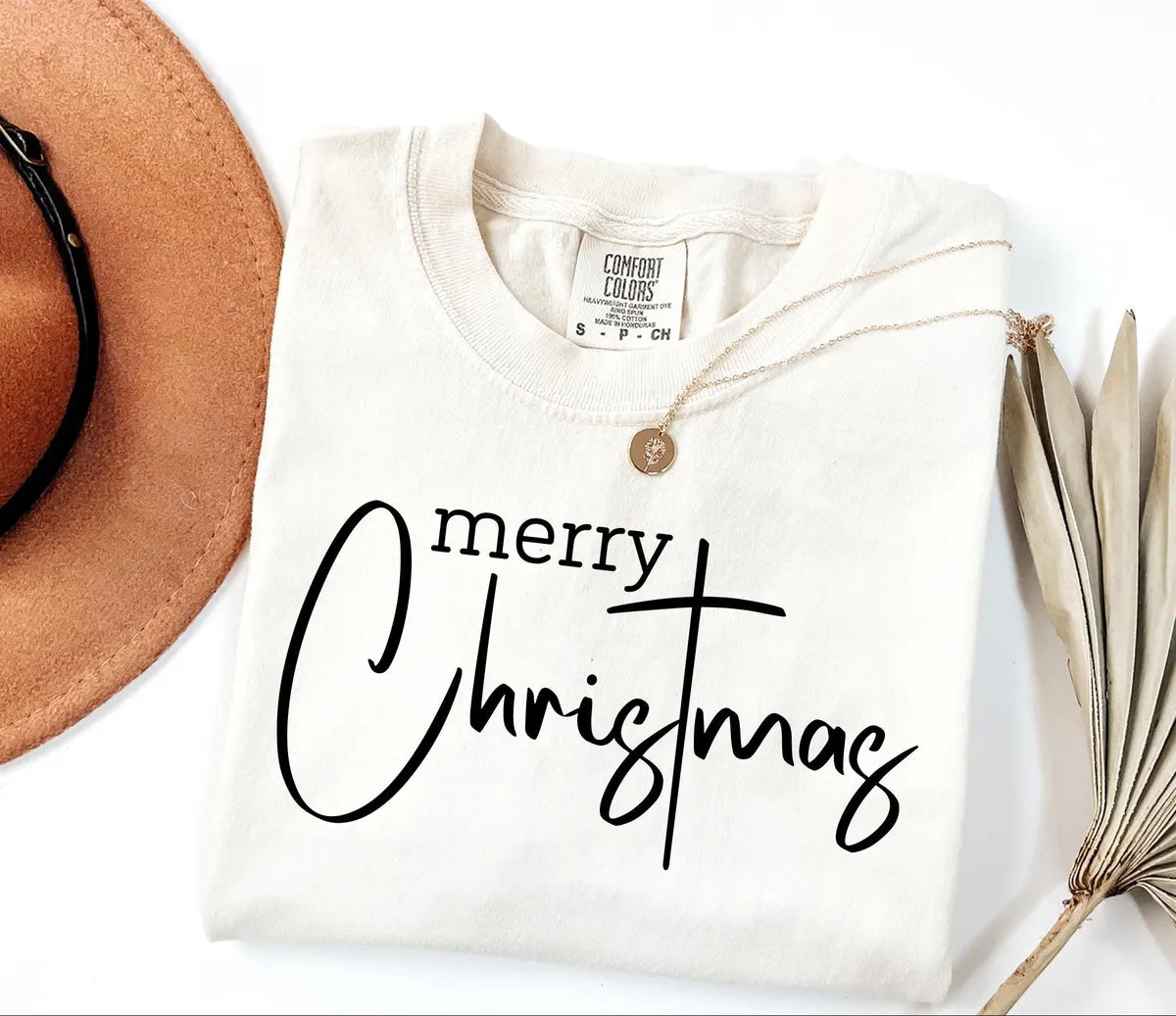 Merry Christmas typography printed in black on an Ivory Comfort Colors T-shirt.