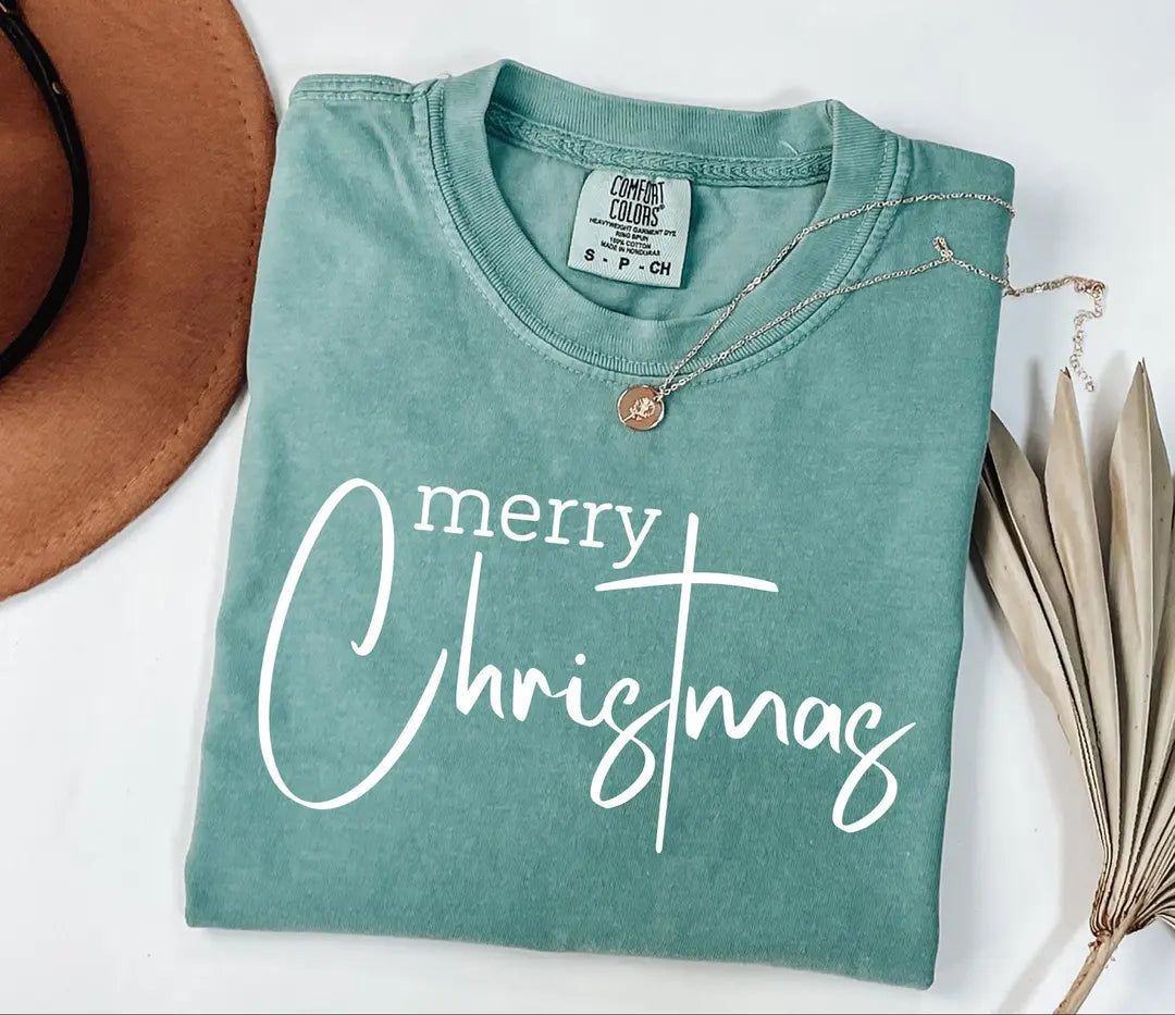 Merry Christmas lettering shown on a pale teal Comfort Colors T-shirt mockup.