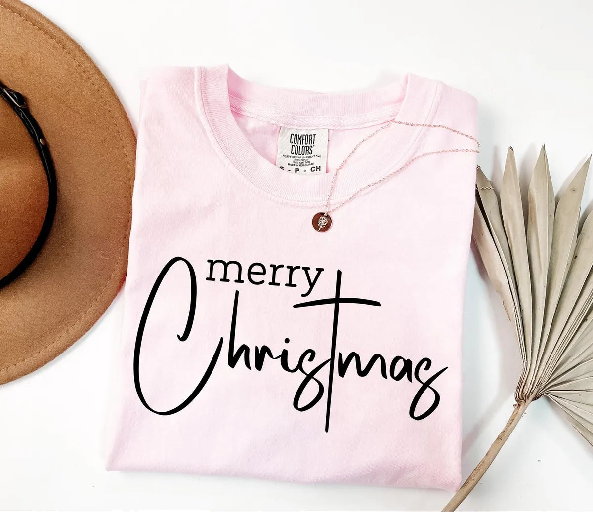 Merry Christmas lettering on a pale pink Blossom Comfort Colors T-shirt.