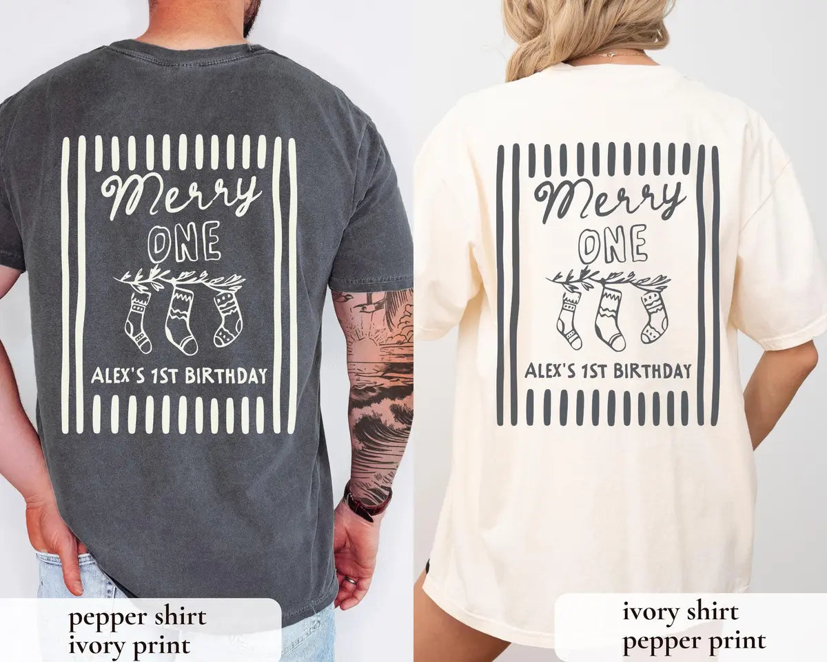 Backs of a Pepper tee with an ivory Merry ONE print and an Ivory tee with a pepper print, worn side by side