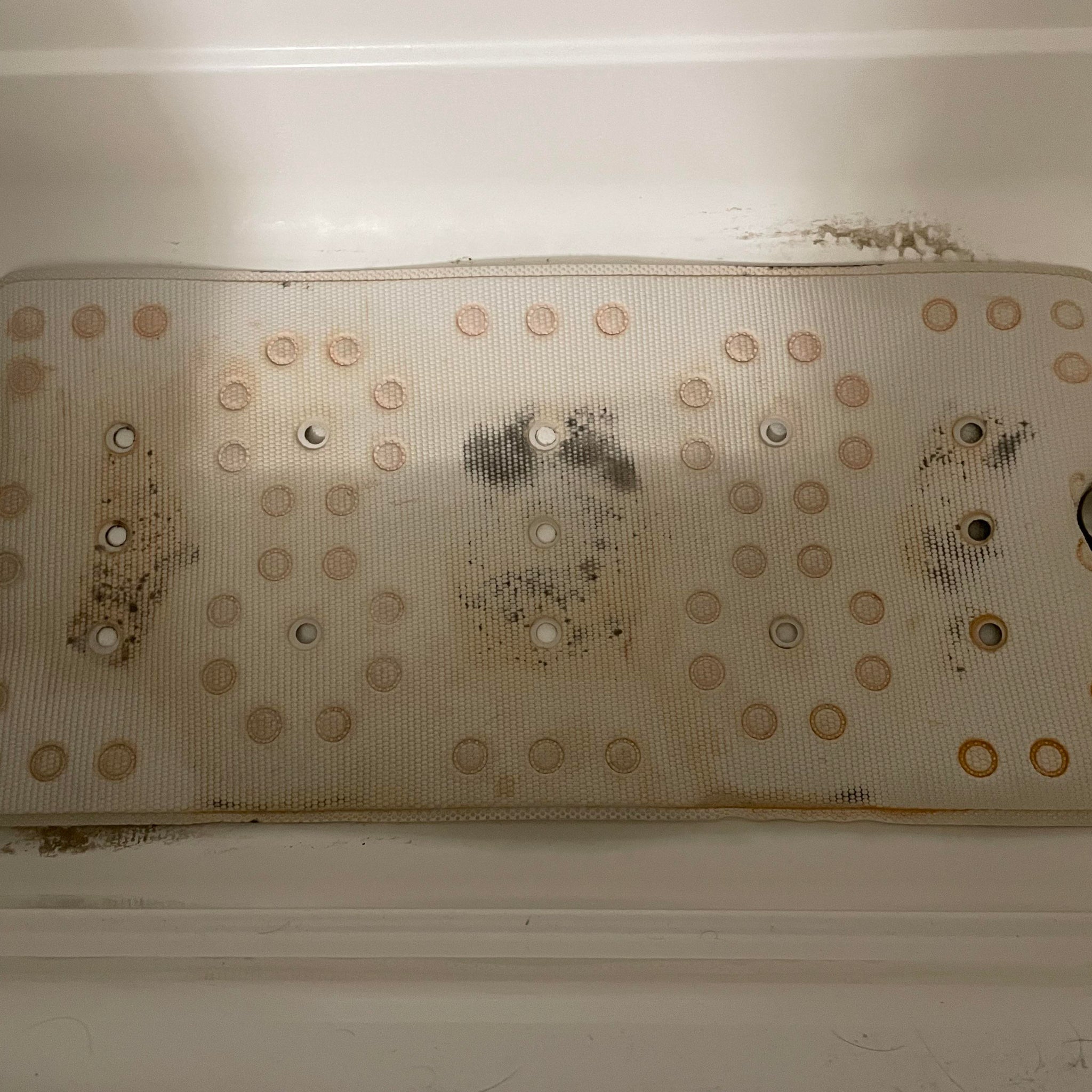 Dirty metal filter inside a white appliance