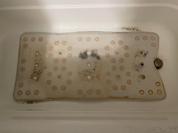 Dirty metal filter inside a white appliance