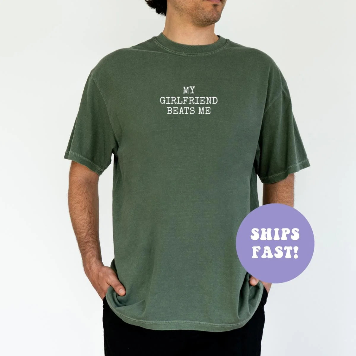 Man in a Moss green Comfort Colors tee, hands in pockets, with MY GIRLFRIEND BEATS ME in white capitals