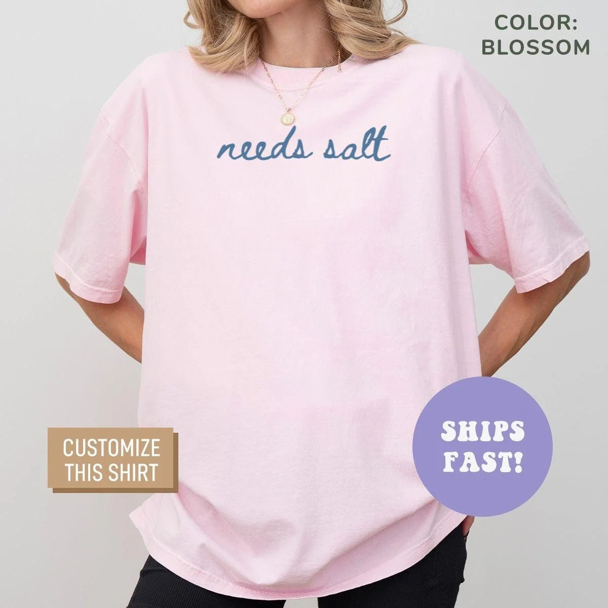Woman in a Blossom pink Comfort Colors tee with needs salt in blue cursive script on the chest