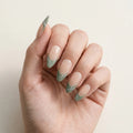 nude sage green french tip almond long press on nails white swirl flat lay 01