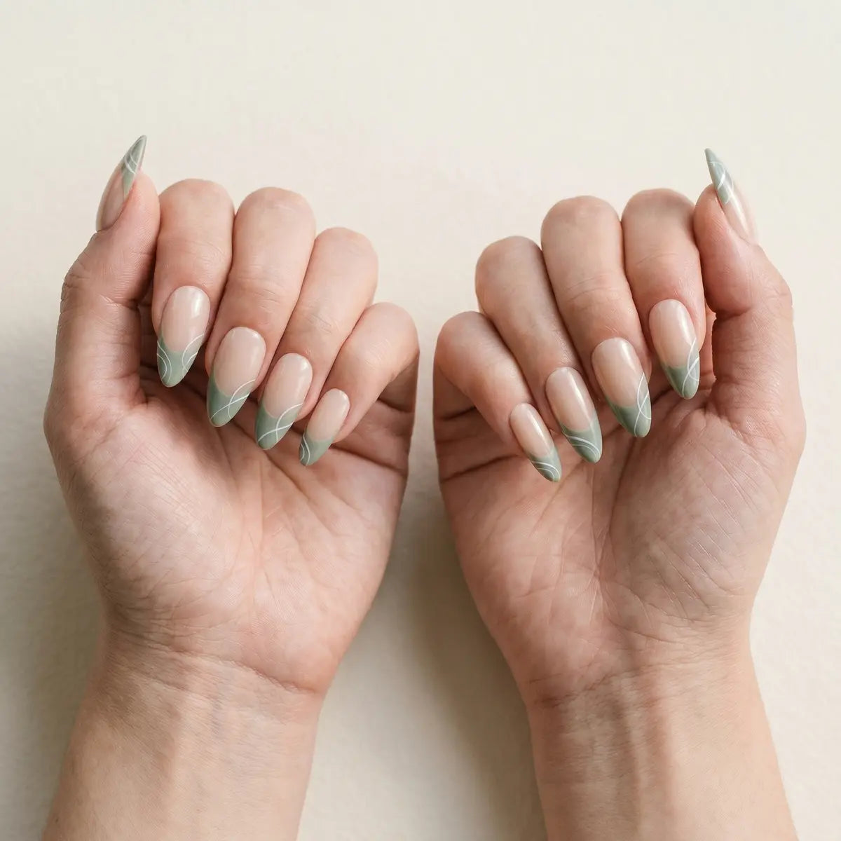 nude sage green french tip almond long press on nails white swirl flat lay 02