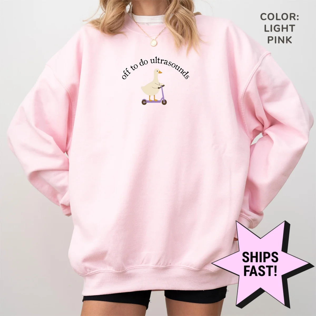 Woman in an oversized Light Pink crewneck sweatshirt, hands in pockets, goose on a scooter under arched ultrasound text